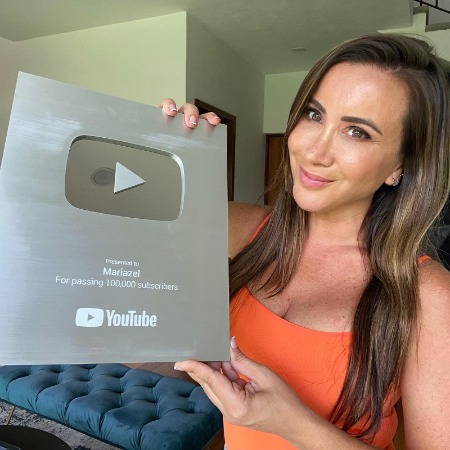 Mariazel Olle Casals showing her silver play button.
